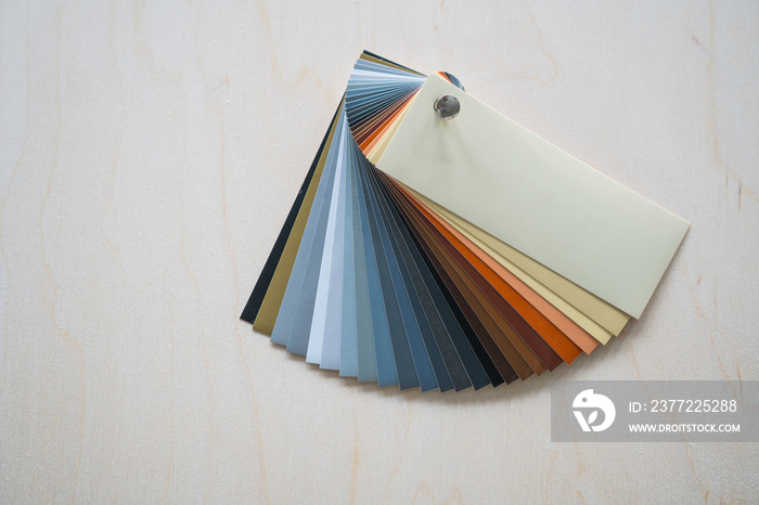 Fan of colorful adhesive vinyls on a wooden background.