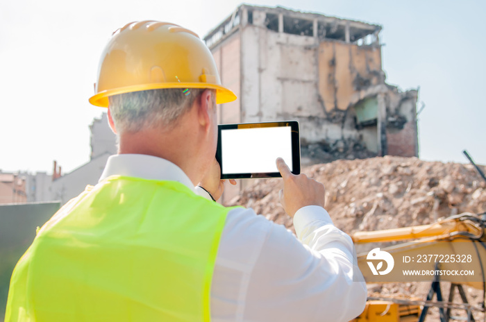 business, building, industry, technology and people concept - smiling builder in hardhat with tablet