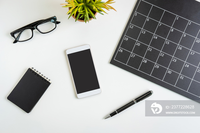 Planning calendar with smartphone on business desk office, Top view