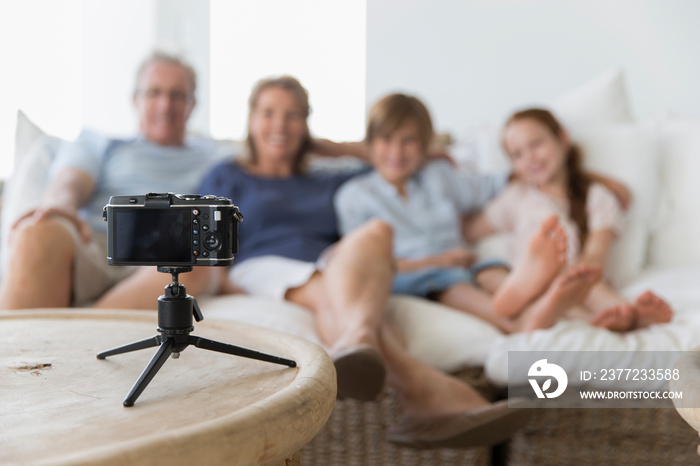 Family posing for automatic photo behind camera on tripod