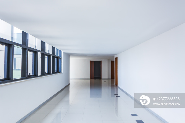 Illuminated long corridor in modern office building