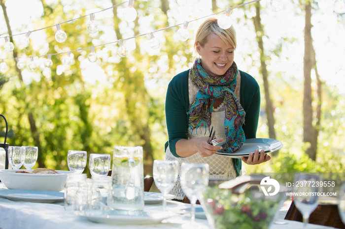 Mid-adult woman setting table for family reunion