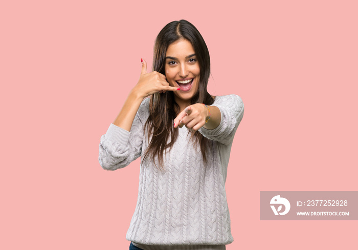 Young hispanic brunette woman making phone gesture and pointing front over isolated background