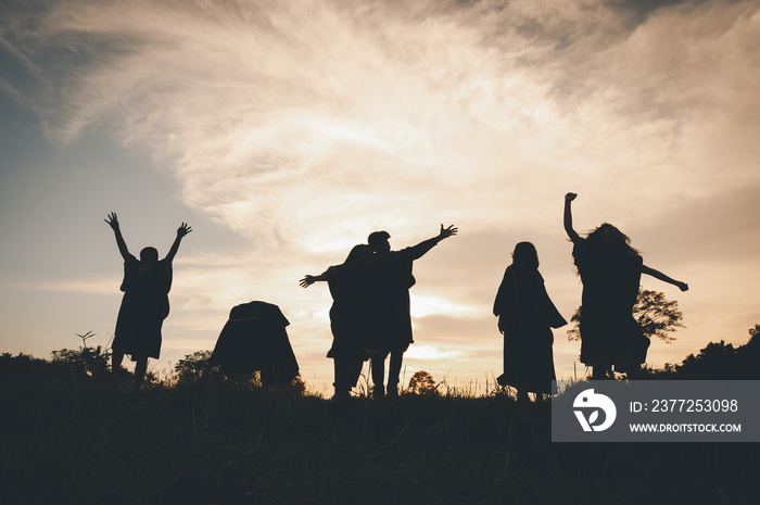 Group of teamwork people jump freedom happy playing at summer sunset in nature