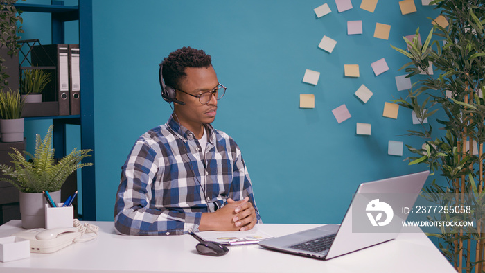 Call center worker talking to client on headset with microphone, helping with telemarketing and sale