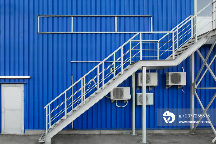 Modern metal stairs of blue building outdoors