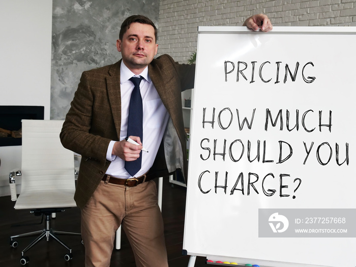 Pricing strategy - How Much Should You Charge. Business Advisor at the blackboard with the inscripti