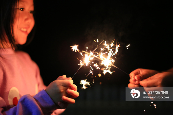 Children are playing with fire sparklers on the festival.