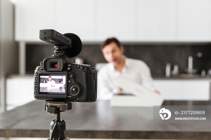 Cheerful young man filming his video blog episode