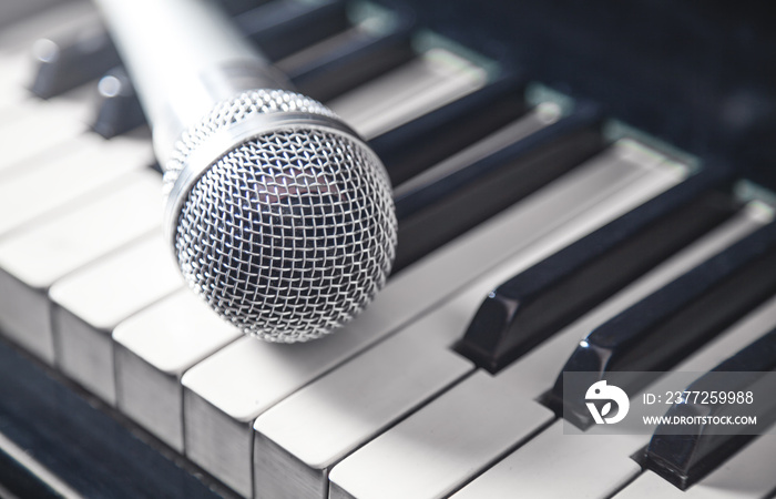 Microphone on piano keyboard. White and black. Music