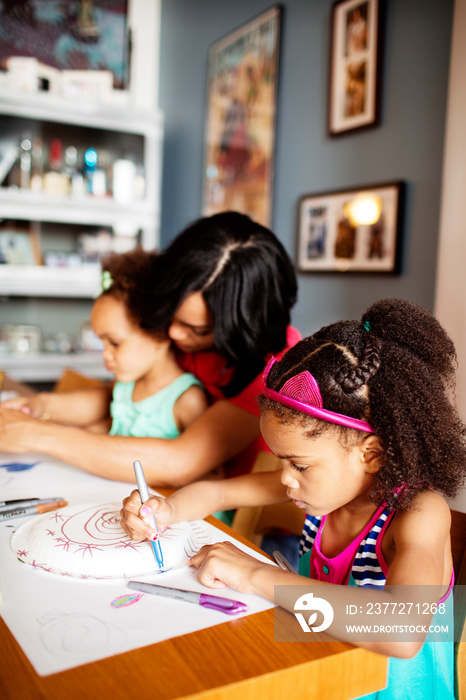 Mother and daughters drawing at home