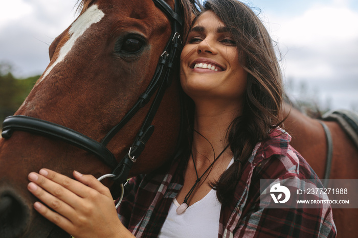 Happy woman hugging her horse