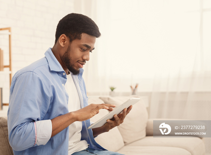 African-american man using digital tablet at home