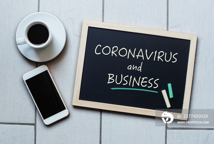 Coronavirus and Business text written on blackboard.