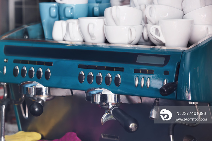 Modern coffee machine with empty cups in cafe