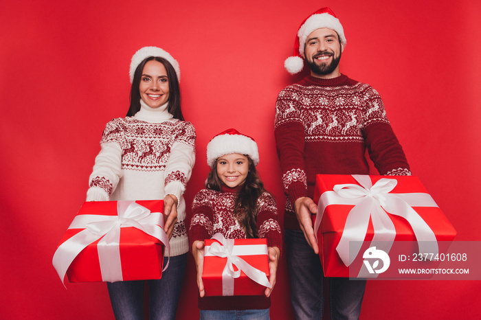 Three cheerful excited relatives, married couple, small girl, hold gifts, knitted traditional costum