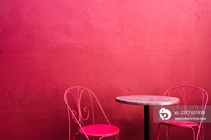 Pink street cafe table with chairs on pink wall