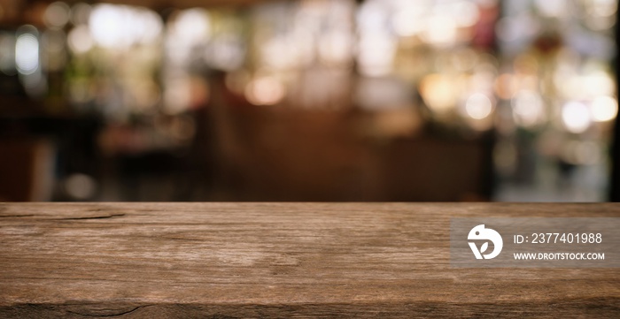 Empty wooden table in front of abstract blurred background of coffee shop . can be used for display 