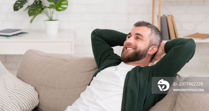 Handsome caucasian man relaxing on sofa at home