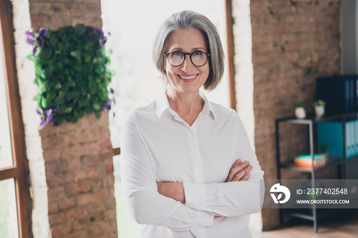 Photo of elegant positive cheerful aged lady crossed hands toothy smile modern spacious office indoo