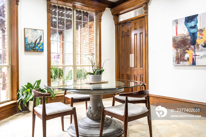 Eclectic casual dining room with glass table, wood trim , high ceilings, windows, eye-level wide