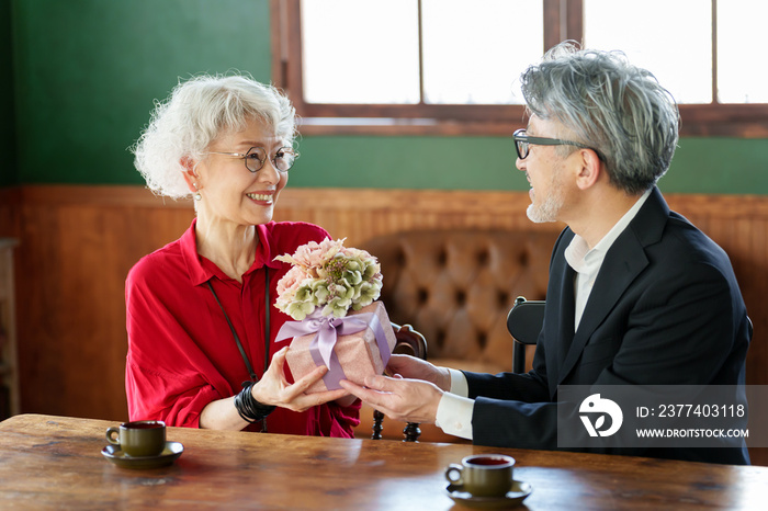 花束をプレゼントする中高年の夫婦