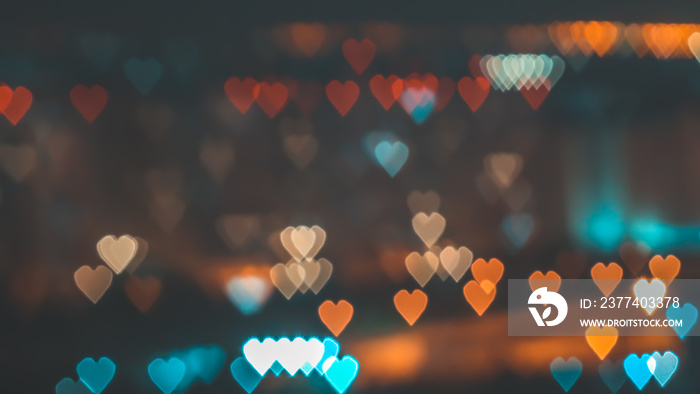 Bokeh of hearth shape of light from building or traffic road for valentine background. in pastel col