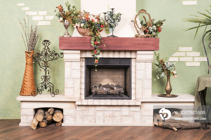 Decorative beautiful fireplace, without fire, with flowers and candlestick