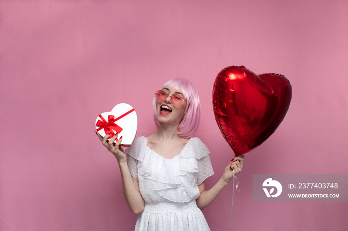 crazy girl with pink hair in a dress holds gifts and inflatable balls and screams
