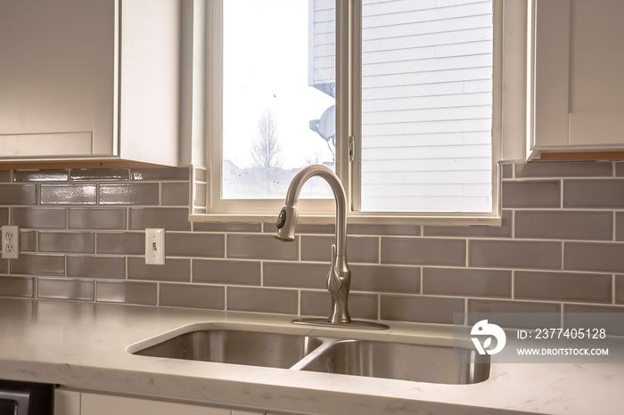 Polished kitchen countertop with double basin stainless steel sink and faucet