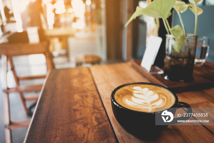 Latte cup on wooden table blur coffee shop background