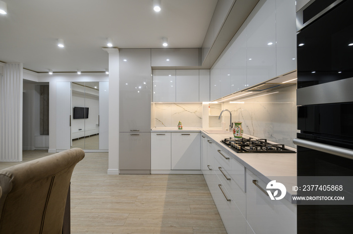 Huge white luxury kitchen in a studio apartment interior