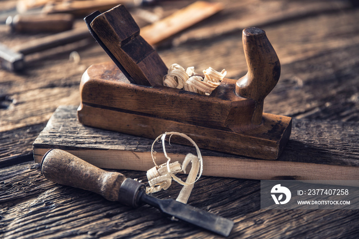 Old planer and other vintage carpenter tools in a carpentry workshop