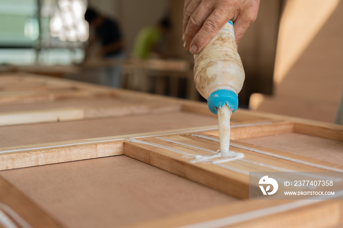 wood work carpenter concept with close up hand use glue for work