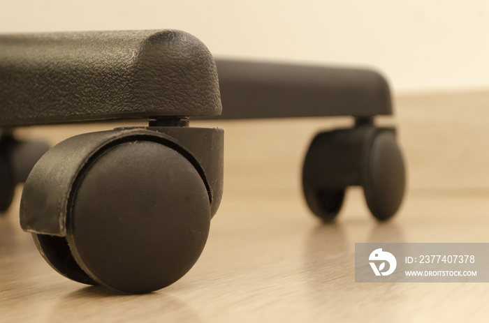 Closeup shot of the black plastic caster wheels of the office chair