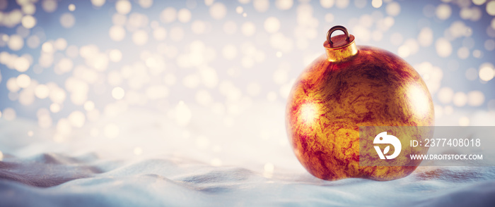 Christmas golden ball on snow. Glitter lights