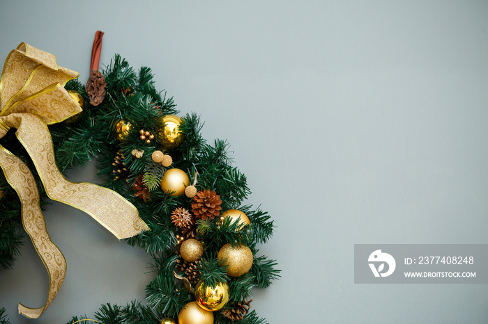 Christmas wreath with branches of a Christmas tree hanging on the wall. New Years decor in a cozy h