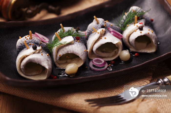 Rolled herring in vinegar, served with onions and pickles.