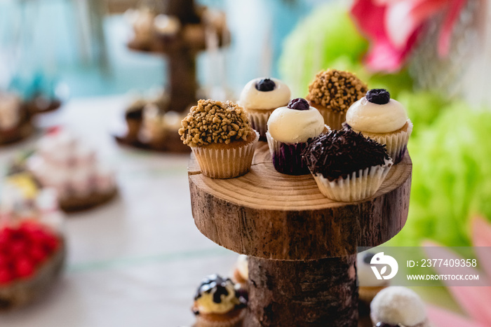 Desserts and wedding cake with very sweet cupcakes at an event.