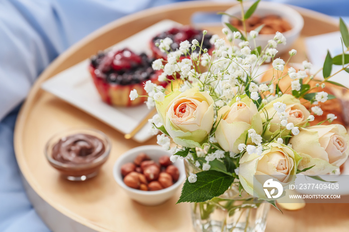 Beautiful bouquet of flowers with tasty breakfast, closeup