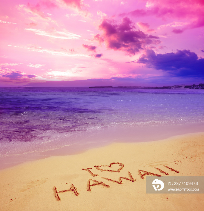 Inscription I love Hawaii on the beach. Hawaii written in the sand at the beach during sunset