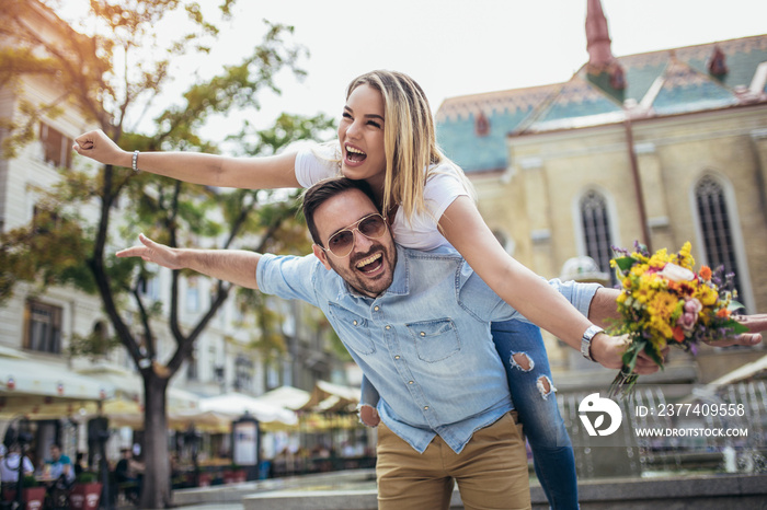 Picture of young man surprising woman with flowers