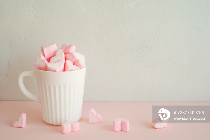 Fluffy pink heart marshmallow in vintage cup on white background with copy space