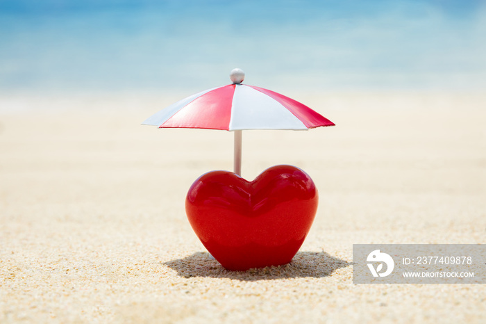 Red Painted Heart Under The Umbrella On Sand