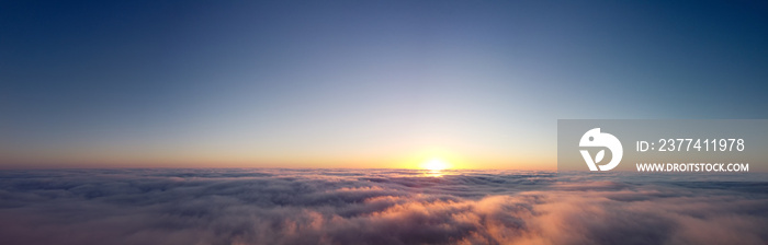 Panorama of sunrise over clouds. Beautiful heavenly landscape.