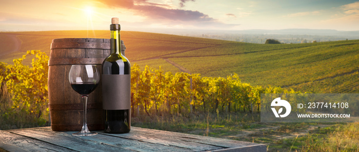 Red wine with barrel on vineyard in green Tuscany, Italy