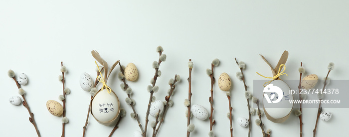 Easter eggs, quail eggs and catkins on white background