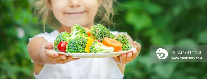 child eats vegetables. Summer photo. Selective focus