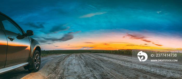 Green SUV Car Parked On Field Country Road Through Summer Maize Field In Amazing Sunset Time. Summertime.