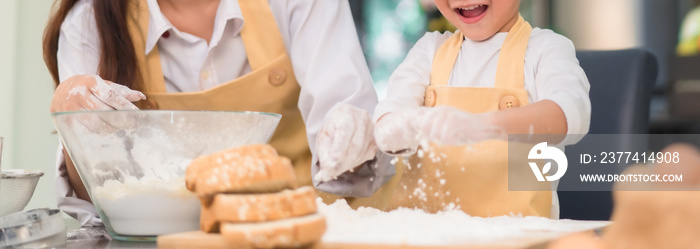 Pastry chef asian mom and son making bakery bread cake prepare delicious sweet food in the kitchen room for dinner at home together happy family lifestyle, Web Banner header.